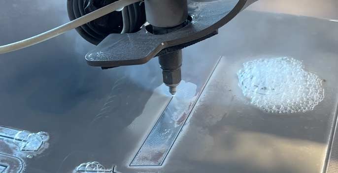 Wasserstrahlschneidanlage in Betrieb schneidet eine Aluminiumplatte